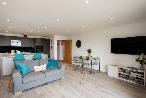 a living room with a couch and a kitchen at Blue Horizon in Sandown