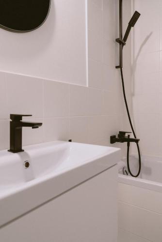 a white bathroom with a sink and a shower at Alfreda in Sokołowsko