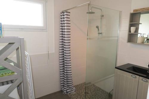 a shower with a glass door in a bathroom at Maison neuve de plain-pied à 100m de la mer et 200m du Coz-Pors à TREGASTEL - Ref 71 in Trégastel