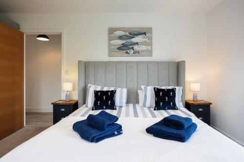 um quarto com uma cama grande e toalhas azuis em The Bay em Sandown