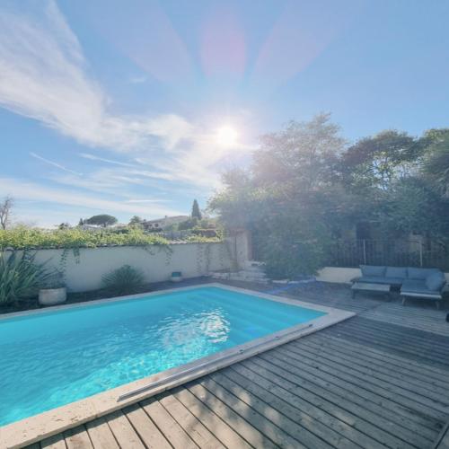 a swimming pool in a yard with a wooden deck at Villa OASIS en Provence Luberon Pierrevert in Pierrevert