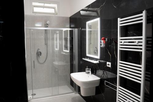 bagno con doccia, lavandino e servizi igienici di San Cataldo Hotel a Faggiano
