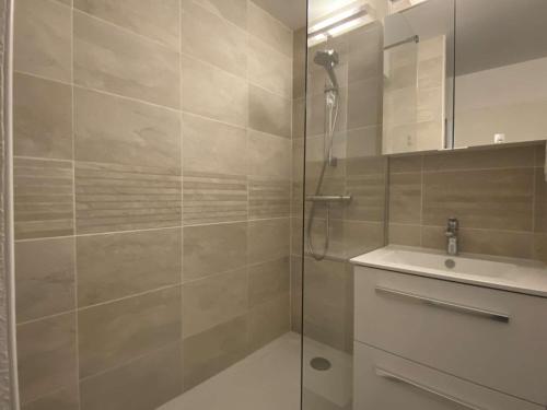 ein Bad mit einer Dusche und einem Waschbecken in der Unterkunft Appartement VUE MER EXCEPTIONNELLE avec WIFI à TREGASTEL - Réf 729 in Trégastel