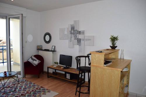 Zimmer mit einem Schreibtisch, einem Computer und einem Stuhl in der Unterkunft Appartement VUE MER EXCEPTIONNELLE avec WIFI à TREGASTEL - Réf 729 in Trégastel