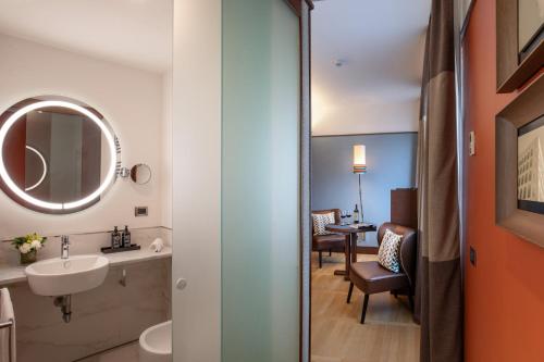 y baño con lavabo y espejo. en The Independent Hotel en Roma