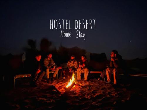 een groep mensen die rond een vuur zitten bij Hostel Desert Home Stay in Jaisalmer