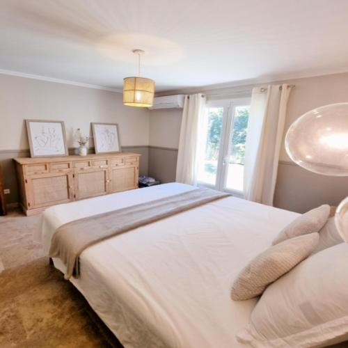 a bedroom with a large white bed and a window at Villa OASIS en Provence Luberon Pierrevert in Pierrevert