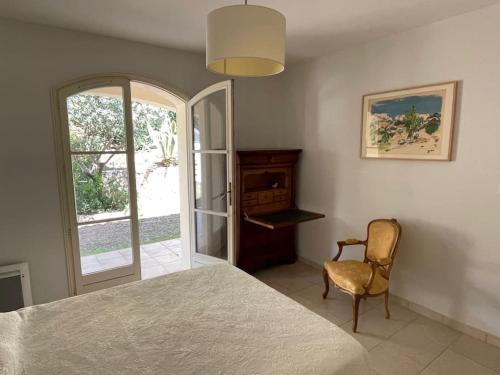 um quarto com uma cama, uma cadeira e uma janela em Maison cosy en bordure du golf. em Saint-Raphaël