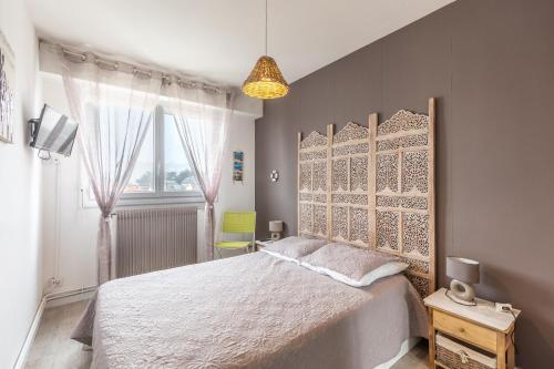 une chambre avec un grand lit blanc avec une fenêtre dans l'établissement Le Valentin - Appt proche des plages, à Saint-Jean-de-Monts