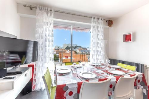 une salle à manger avec une table et une grande fenêtre dans l'établissement Le Valentin - Appt proche des plages, à Saint-Jean-de-Monts