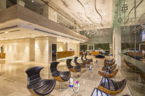 a lobby with chairs and tables in a building at Liberty Central Saigon Riverside Hotel in Ho Chi Minh City