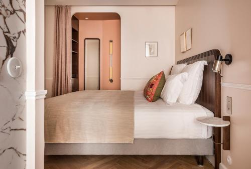 a bedroom with a large bed with white pillows at Hôtel Chamar in Paris