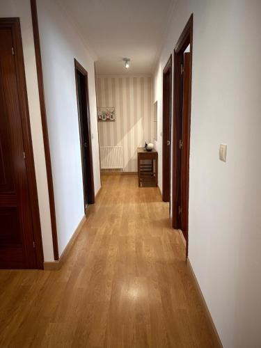 シグエイロにあるPISO OROSO NO CAMIÑOの二つのドアと木製の床の廊下