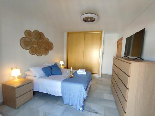ein Schlafzimmer mit einem Bett und einem Flachbildfernseher in der Unterkunft Apartamentos Playacala in La Cala del Moral