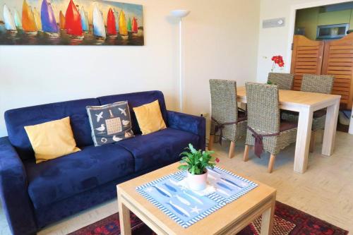 un salon avec un canapé bleu et une table dans l'établissement Superbe appartement TRES BELLE VUE MER à PERROS-GUIREC - Ref 819, à Perros-Guirec
