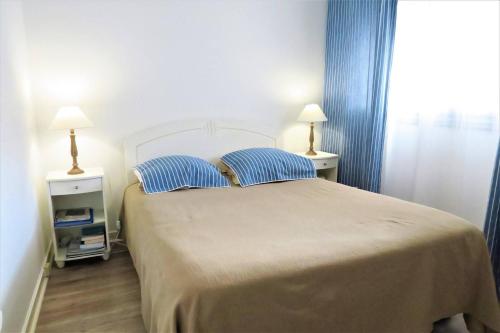 une chambre avec un grand lit avec des rideaux bleus dans l'établissement Superbe appartement TRES BELLE VUE MER à PERROS-GUIREC - Ref 819, à Perros-Guirec
