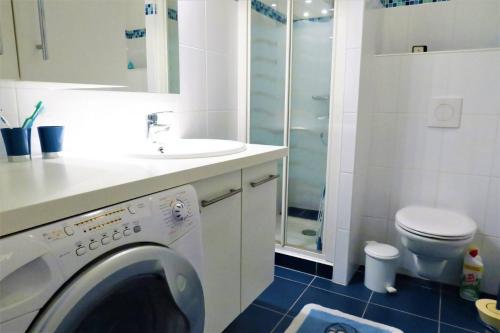 une salle de bain avec une machine à laver et un lavabo dans l'établissement Superbe appartement TRES BELLE VUE MER à PERROS-GUIREC - Ref 819, à Perros-Guirec
