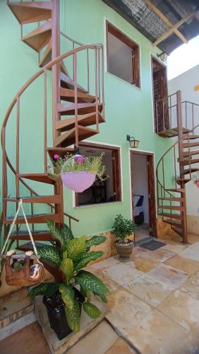 una habitación con escaleras y plantas en un edificio en Suítes Preguiça en Canoa Quebrada