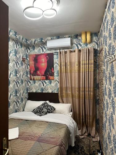 1 dormitorio con 1 cama con papel pintado azul y blanco en Magenta Roma house en Roma