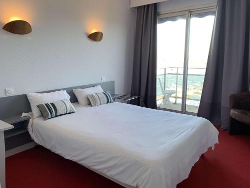 - une chambre avec un grand lit blanc et un balcon dans l'établissement Superbe appartement TRES BELLE VUE MER à PERROS-GUIREC - Ref 823, à Perros-Guirec