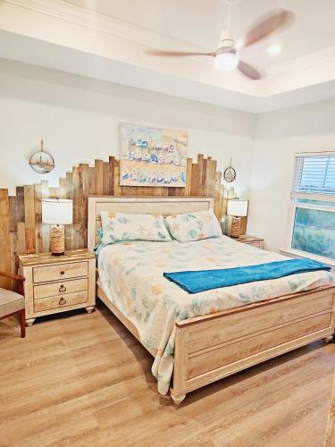 a bedroom with a large bed and a night stand at Coastal Dreaming - Beach Retreat in Saint Joe Beach
