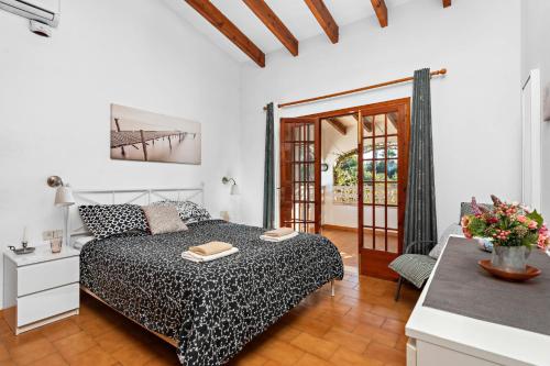 una camera bianca con letto e tavolo di Villa Cas Sucrer by Villa Plus a Binibeca