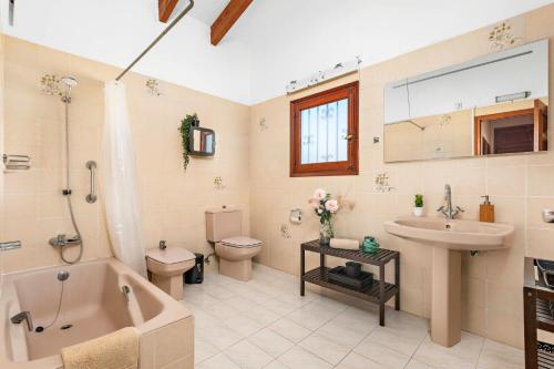 e bagno con vasca, servizi igienici e lavandino. di Villa Cas Sucrer by Villa Plus a Binibeca