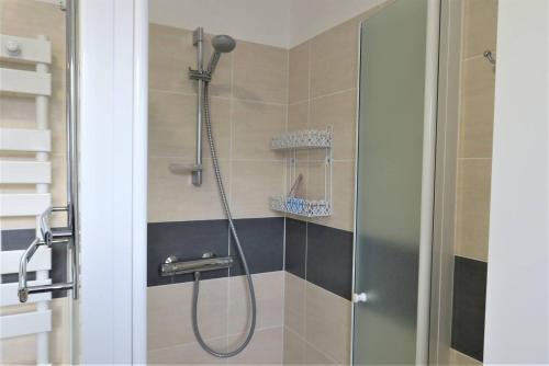 une douche dans une salle de bain avec une porte vitrée dans l'établissement Appartement VUE MER avec terrasse et WIFI à PERROS-GUIREC - Réf 828, à Perros-Guirec