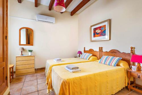 a bedroom with two beds and a dresser and a mirror at Villa Bini Cinco by Villa Plus in Binibeca