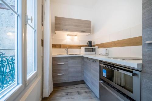 Il comprend une cuisine équipée d'un évier et d'une fenêtre. dans l'établissement La Panacée, Charmant T3, Centre Historique, à Montpellier