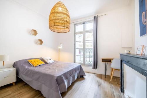 une chambre avec un lit, un bureau et une fenêtre dans l'établissement La Panacée, Charmant T3, Centre Historique, à Montpellier