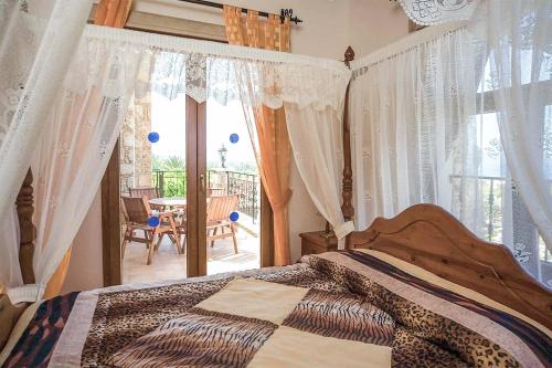 um quarto com uma cama com cortinas e uma varanda em Villa Stavroulla em Argaka