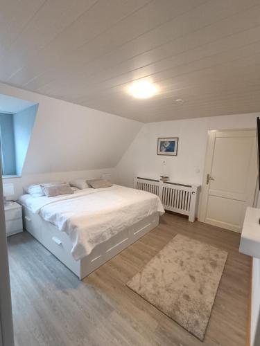 a bedroom with a white bed and a rug at LütjeFöhr in Alkersum