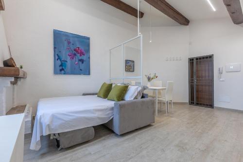 a white bedroom with a bed and a table at Coperta Retreat! Near Estense Castle in Ferrara