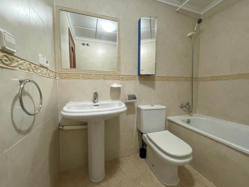 a bathroom with a sink and a toilet and a tub at Apartamentos Madeira 3000 in Alcossebre