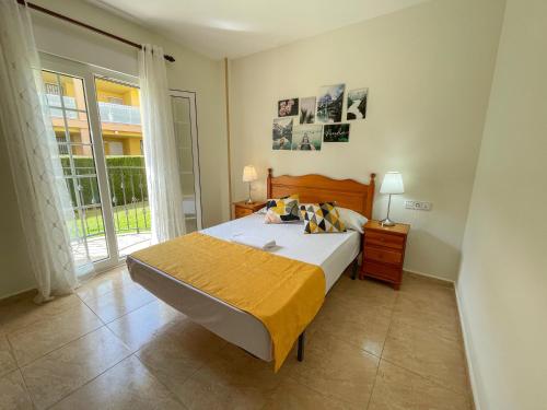a bedroom with a large bed and a large window at Apartamentos Madeira 3000 in Alcossebre