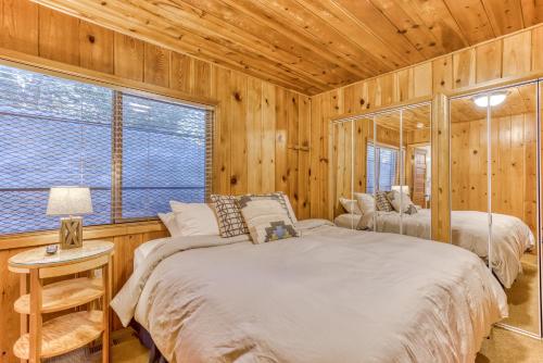 two beds in a room with wooden walls at Sno-Bird #10 in Government Camp