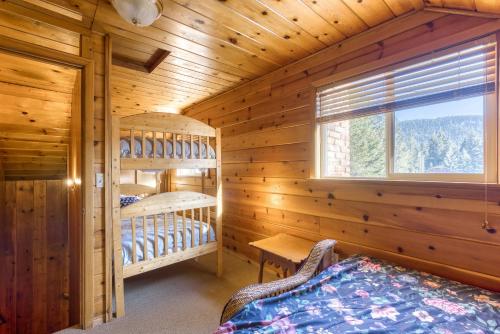 a log cabin with a bed and a window at Sno-Bird #10 in Government Camp