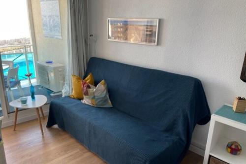 un canapé bleu avec des coussins dans un salon dans l'établissement Elegance sea view with swimming pool, à Frontignan