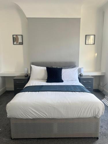 a bedroom with a large bed with white sheets and pillows at No. 73 in Liverpool