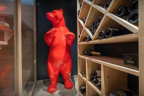 eine rote Bärenstatue in einem Weinkeller in der Unterkunft Chalet Ours Rouge - OVO Network in Le Grand-Bornand