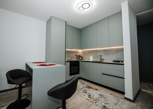 una cocina con armarios grises y sillas negras en Nil's Apartments, en Peje
