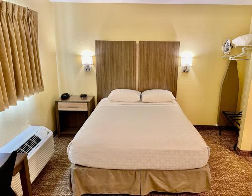 a bedroom with a large bed in a hotel room at Suburban Studios Fort Myers Cape Coral in Fort Myers