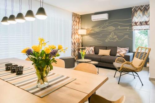 a living room with a vase of flowers on a table at EMMY Ház in Badacsonytomaj