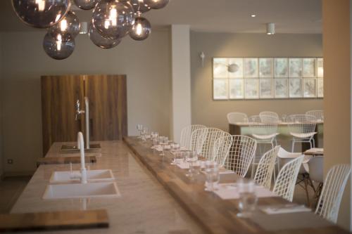 a long table in a room with white chairs at Lagrange Aparthotel Montpellier Millénaire in Montpellier
