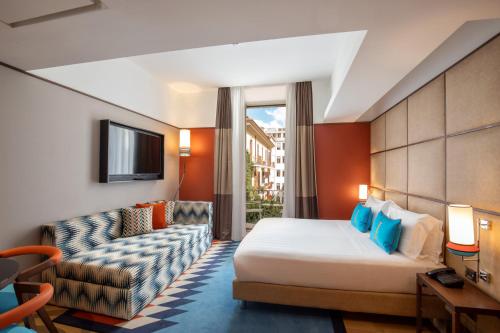 ローマにあるジ インディペンデント ホテルのベッドとソファ付きのホテルルーム