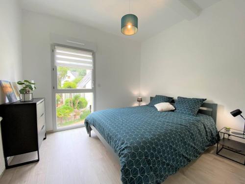 une chambre avec un lit bleu et une fenêtre dans l'établissement Appartement avec balcon terrasse à PERROS-GUIREC - Réf 844, à Perros-Guirec