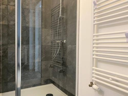 une douche avec une porte vitrée dans une salle de bain dans l'établissement Appartement avec balcon terrasse à PERROS-GUIREC - Réf 844, à Perros-Guirec