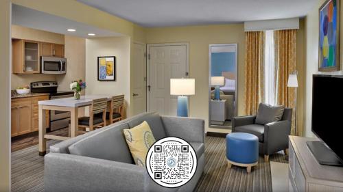 a living room with a couch and a table and a kitchen at Sonesta Simply Suites Dublin Columbus in Dublin