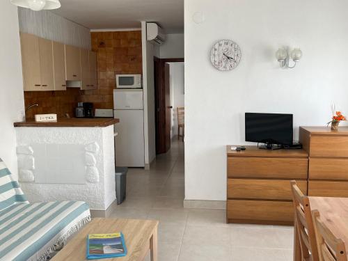 a kitchen and a living room with a couch and a tv at Apartamentos Miradores in Miami Platja